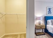 Thumbnail 20 of 24 - a bedroom with a closet and a bed and a nightstand with a lamp