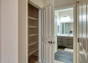 Thumbnail 21 of 24 - a walk in closet in a home with a door open to a bathroom