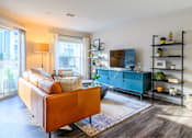 Thumbnail 5 of 20 - A living room with a brown leather couch, a blue cabinet, and a TV on a stand.
