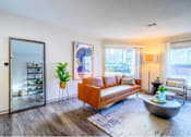 Thumbnail 4 of 20 - A living room with a brown sofa and a grey coffee table.