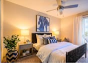 Thumbnail 6 of 20 - A bedroom with a large bed and a ceiling fan.