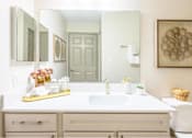 Thumbnail 9 of 20 - A bathroom with a white sink and a large mirror.