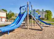 Thumbnail 2 of 36 - A blue slide in a playground with a wooden structure.