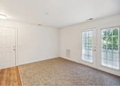 Thumbnail 23 of 36 - A room with a white door, carpeted floor, and a window with blinds.