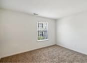 Thumbnail 25 of 36 - A room with a window and carpeted floor.