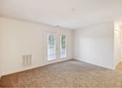 Thumbnail 28 of 36 - A room with a carpeted floor and a window with a view of trees.