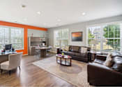 Thumbnail 35 of 36 - A living room with a brown leather couch and a wooden floor.