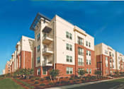 Thumbnail 62 of 62 - A large apartment building with multiple balconies and a green lawn in front.