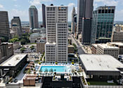 Thumbnail 30 of 55 - A cityscape with a pool in the foreground and tall buildings in the background.