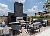 Thumbnail 28 of 55 - A modern outdoor seating area with a fireplace.