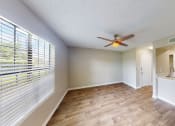 Thumbnail 28 of 40 - a living room with a large window and a ceiling fan