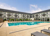 Thumbnail 49 of 81 - a swimming pool with lounge chairs in front of an apartment building at Ainsworth, Virginia, 23228
