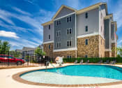 Thumbnail 4 of 35 - a swimming pool in front of an apartment building