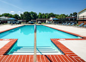 Thumbnail 2 of 26 - A large rectangular pool with a red tile edge and a blue water surface.