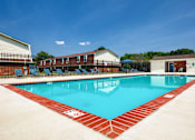 Thumbnail 3 of 26 - A large swimming pool with a red border and a white sign on the side.