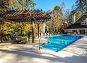 Thumbnail 56 of 67 - A large outdoor swimming pool with a wooden pergola over it.