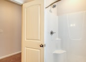 Thumbnail 30 of 35 - a white shower in a bathroom with a door