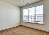 Thumbnail 5 of 40 - an empty living room with a large window and carpeting