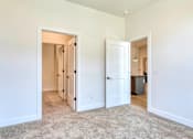 Thumbnail 8 of 29 - A white room with a carpeted floor and two open doors leading to other rooms at Aviator Lofts, Newport News, VA