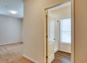 Thumbnail 27 of 35 - a living room with a door and a hallway to a bedroom