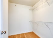 Thumbnail 11 of 21 - an empty closet with white walls and a hanging rack on the wall