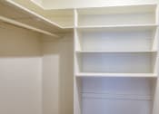 Thumbnail 22 of 24 - a walk in closet with white shelving and white walls at Gates of West Bay in Norfolk, VA 23503