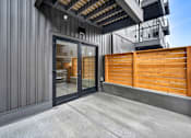 Thumbnail 23 of 27 - A modern building with a wooden fence and glass doors.