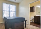 Thumbnail 44 of 60 - an empty bedroom with a bed and a bathroom at Proximity at ODU, Norfolk, VA, 23508