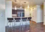 Thumbnail 41 of 60 - a living room with a kitchen bar and stools at Proximity at ODU, Virginia, 23508