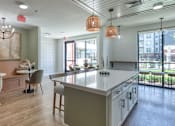 Thumbnail 34 of 40 - A modern kitchen with a dining area and a view of the city.