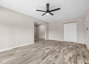 Thumbnail 38 of 52 - an empty living room with wood flooring and a ceiling fan at Bayville Apartments, Virginia Beach, 23455