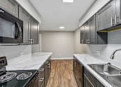Thumbnail 60 of 77 - A kitchen with dark cabinets and a white counter top.