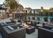 Thumbnail 27 of 35 - a patio with chairs and a fire pit near a pool at Midtown Crossing, Raleigh