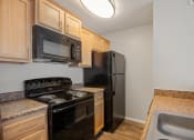 Thumbnail 9 of 22 - a kitchen with black appliances and granite counter tops