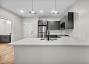 Thumbnail 14 of 27 - A modern kitchen with a large island and stainless steel appliances.