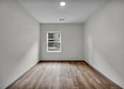 Thumbnail 27 of 27 - A room with a window and wooden flooring.
