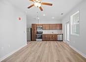 Thumbnail 1 of 31 - A kitchen with wooden cabinets and a ceiling fan.