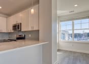Thumbnail 42 of 47 - a kitchen with white cabinets and a large window at The Port at East Beach Apartments and Marina, Virginia, 23518
