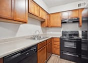 Thumbnail 31 of 33 - an empty kitchen with black appliances and wooden cabinets