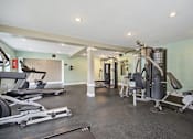 Thumbnail 8 of 33 - a gym with cardio equipment and weights on the floor