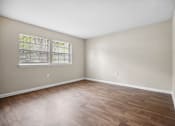 Thumbnail 26 of 33 - an empty living room with wood flooring and a window