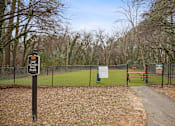 Thumbnail 11 of 33 - a dog park with a bench and a fence