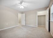 Thumbnail 30 of 33 - an empty living room with a ceiling fan and a closet