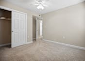 Thumbnail 17 of 33 - an empty living room with a white door and a ceiling fan