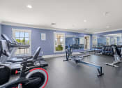 Thumbnail 18 of 29 - a gym with cardio equipment and weights in a building with blue walls