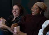 Thumbnail 32 of 60 - two women sitting on a couch laughing and eating popcorn at Proximity at ODU in Norfolk, Virginia 23508