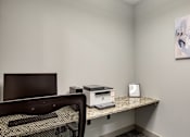 Thumbnail 69 of 88 - A room with a desk, chair, and a painting on the wall.