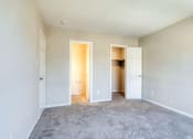 Thumbnail 48 of 52 - an empty living room with carpet and a door to a closet at Bayville Apartments, Virginia Beach, VA