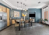 Thumbnail 11 of 55 - a kitchen with stainless steel appliances and a table with chairs at The Lincoln in North Carolina 27601