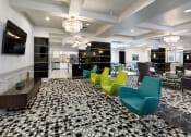 Thumbnail 23 of 46 - a lobby with yellow and blue chairs and a black and white carpet